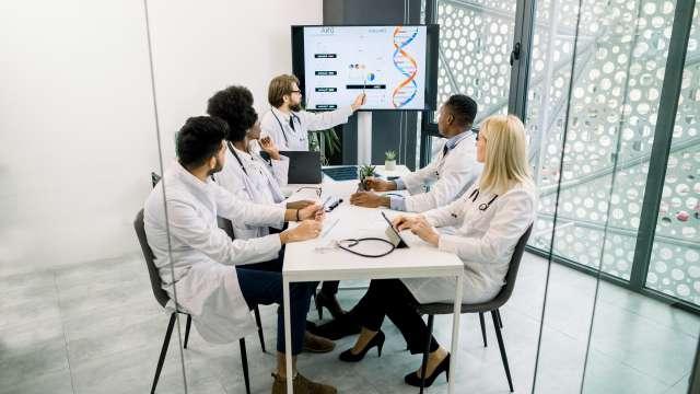 Doctors discussing a presentation in hospital conference room