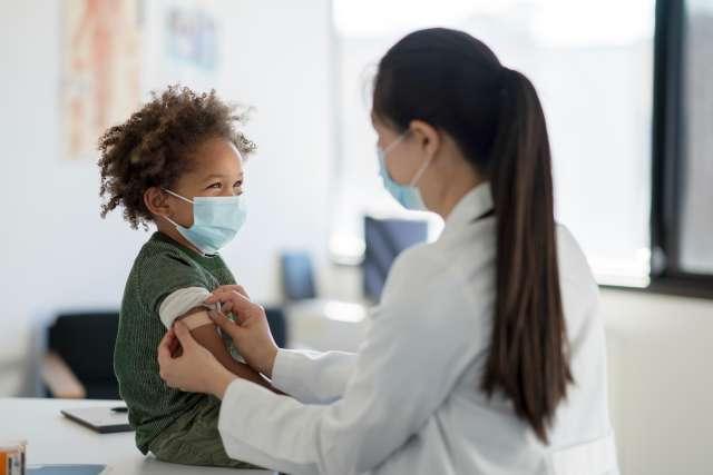 Pediatrian putting bandage on child