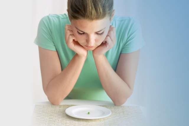 女人看着盘子里的一颗豌豆