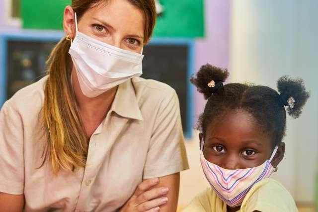 Girl and educator with face mask