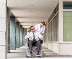 provider pushing patient in wheelchair